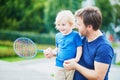 Little boy playing badminton with dad on the playground Royalty Free Stock Photo