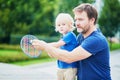 Little boy playing badminton with dad on the playground Royalty Free Stock Photo