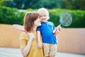 Little boy playing badminton with mom on the playground