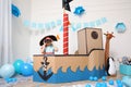 Little boy playing with binoculars in pirate cardboard ship at home. Child`s room interior Royalty Free Stock Photo