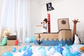 Little boy playing with binoculars in pirate cardboard ship at home. Child`s room interior Royalty Free Stock Photo