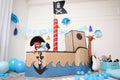 Little boy playing with binoculars in pirate cardboard ship at home. Child`s room interior Royalty Free Stock Photo