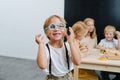 Little boy playing with blue plastic toy glasses, radiantly smiling.