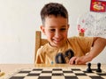 Little boy playing chess at home. Chess board game for kids. Royalty Free Stock Photo