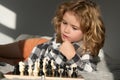 Little boy are playing chess at home. Clever concentrated and thinking child playing chess. Child boy developing chess Royalty Free Stock Photo