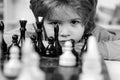 Little boy playing chess. Kids educational games, child early development. Boy think or plan about chess game, vintage