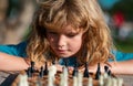 Little boy playing chess outdoor in park. Close up face of clever smart child. Royalty Free Stock Photo