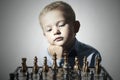 Little boy playing chess.Smart kid.Little genius Child. Intelligent game.Chessboard Royalty Free Stock Photo