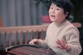 little boy playing the Chinese zither