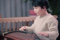 little boy playing the Chinese zither