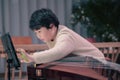 little boy playing the Chinese zither