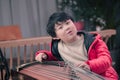 little boy playing the Chinese zither