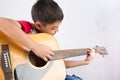 Little boy playing classic guitar course on white background