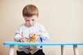 Little boy playing with colored toy car on a table Royalty Free Stock Photo