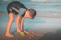 Little boy playing with colorful plastic toy and sand on the beach for kid summer vacation concept Royalty Free Stock Photo