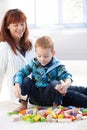 Little boy playing with cubes mother watching Royalty Free Stock Photo