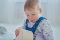 Little boy playing with empty gift box in bright white room - close up view Royalty Free Stock Photo