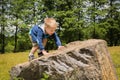 Little boy playing in a field near the big stones Royalty Free Stock Photo