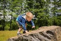 Little boy playing in a field near the big stones Royalty Free Stock Photo