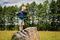 Little boy playing in a field near the big stones Royalty Free Stock Photo