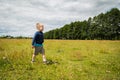 Little boy playing in a field near the big stones Royalty Free Stock Photo