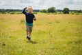 Little boy playing in a field near the big stones Royalty Free Stock Photo