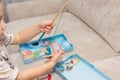 a little boy playing fisherman catches wooden fish in a box with a toy fishing rod with a magnet. Royalty Free Stock Photo