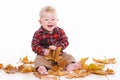 Little boy playing on the floor with maple leaves. Royalty Free Stock Photo