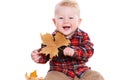 Little boy playing on the floor with maple leaves. Royalty Free Stock Photo