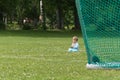 Little boy playing on the football field with gates Royalty Free Stock Photo