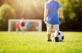 Little boy playing football on the field with gates Royalty Free Stock Photo