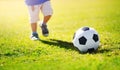 Little boy playing football on the field with gates Royalty Free Stock Photo