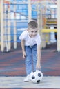 Little boy playing football soccer on the field