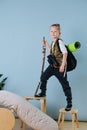 Little boy playing hiker at home. Wearing backpack, holding hiking stick Royalty Free Stock Photo