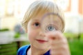 Little boy playing with magnifying glass. Baby carefully looking at you with magnifier. Activity for inquisitive child. Charming Royalty Free Stock Photo