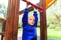 Little boy playing on monkey bars at playground Royalty Free Stock Photo