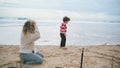 Little boy playing ocean shore with mother. Family weekend on autumn beach. Royalty Free Stock Photo