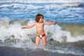 Little boy playing in outdoor jumping into water on summer vacation on tropical beach island. Happy child playing in the Royalty Free Stock Photo