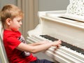 A little boy is playing the piano.