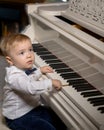 A little boy is playing the piano.