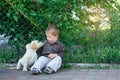 Little boy playing with a puppy labrador in the park Royalty Free Stock Photo