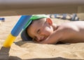 A little boy is playing in the sand on the sea, little legs and fingers, in a swimsuit, a background of sea yellow sand and blue w Royalty Free Stock Photo