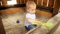 Little boy playing in sandpit with plastic toys and digging sand Royalty Free Stock Photo