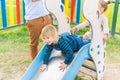Little boy playing slider at playground with his little sister Royalty Free Stock Photo