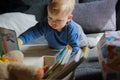 little boy playing on sofa with books and stuffed animals Royalty Free Stock Photo