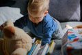little boy playing on sofa with books and stuffed animals Royalty Free Stock Photo
