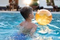 Little boy playing in swimming pool with beach ball Royalty Free Stock Photo