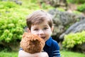 little boy playing with a teddy bear in the garden Royalty Free Stock Photo