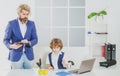 Little boy playing to be boss on a business desk in office. Businessmans crew working with new startup project in office Royalty Free Stock Photo