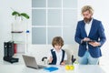 Little boy playing to be boss on a business desk in office. Businessmans crew working with new startup project in office Royalty Free Stock Photo